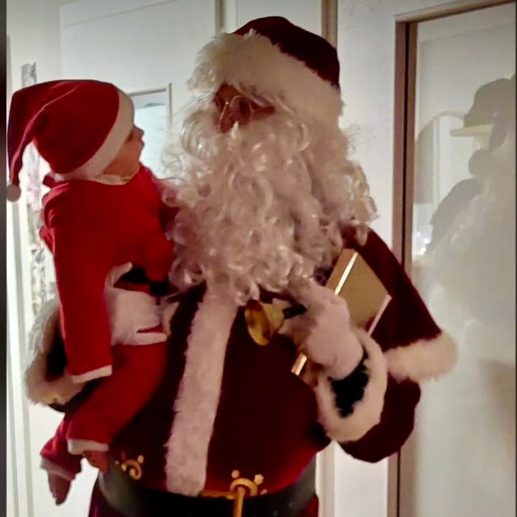 Der Weihnachtsmann hält ein Kind auf dem Arm