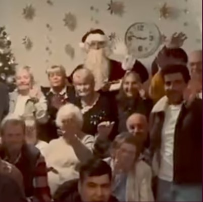 Seniorinnen und Senioren winken zusammen mit dem Weihnachtsmann